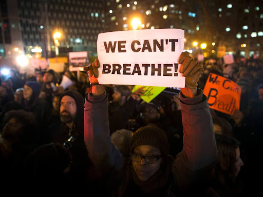 person holding a sign that says we can't breathe