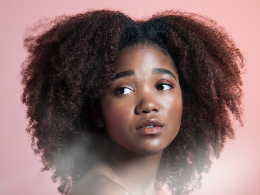 black girl with curly hair looking off into the distance