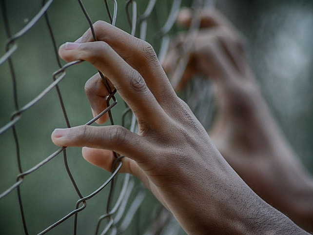 Hands on fence