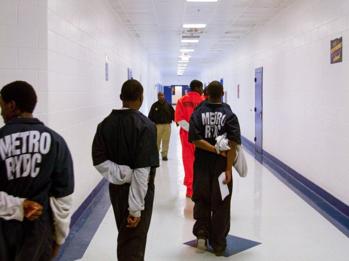 Young inmates walking in hallway