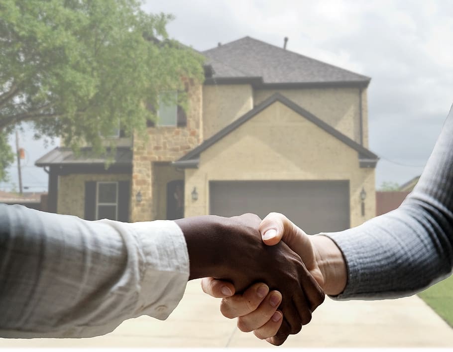 Hands shaking in front of house