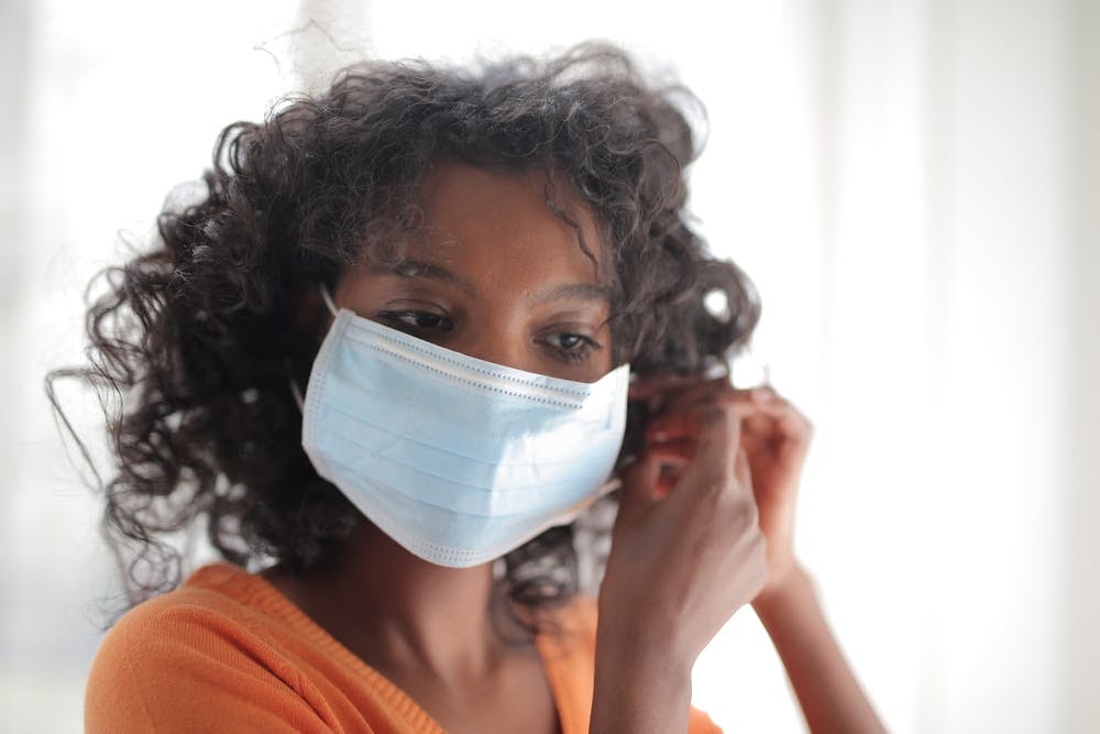 Woman putting on face mask