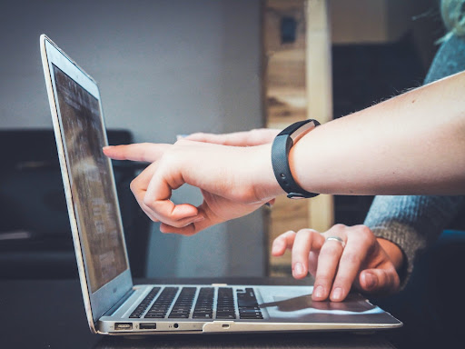 hands pointing at a laptop