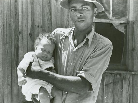 Tenant farmer holding newborn child