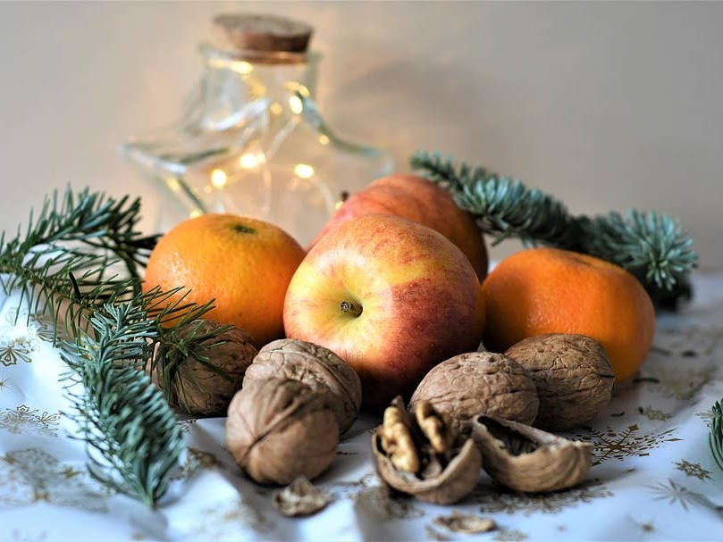 Apples, oranges and walnuts on table