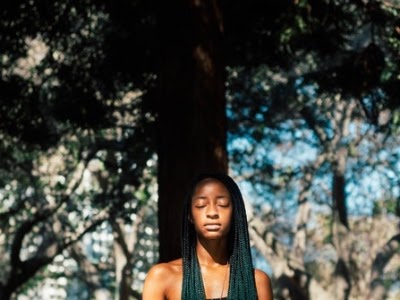 Woman under tree with cornrows