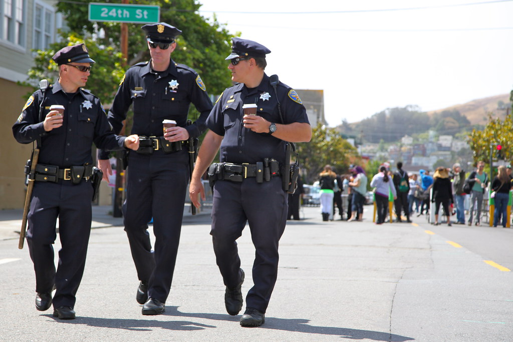 Cops walking with coffee away from a crowd