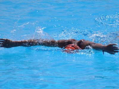 black man doing the breast stroke in a pool