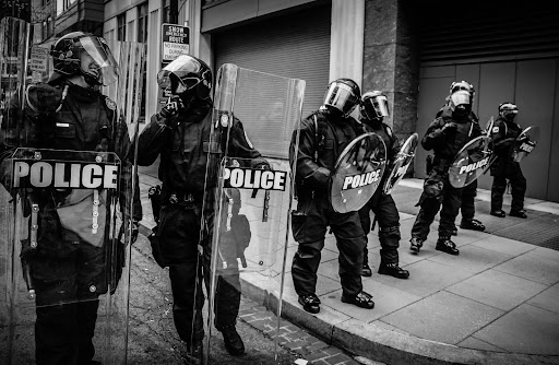 police with riot shields and riot gear standing in a line