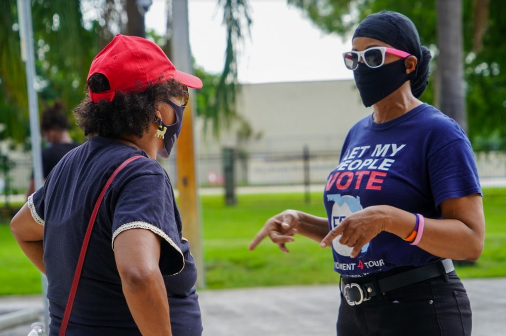 Women with face masks speaking to each other
