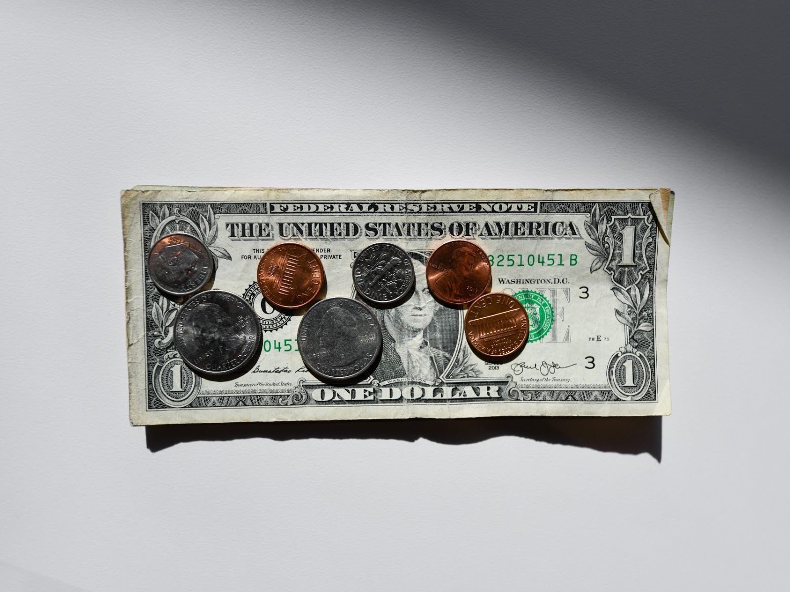 coins on the top oof a dollar bill