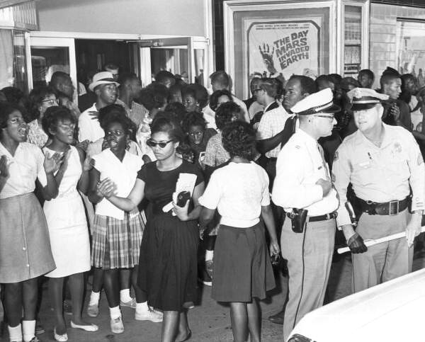 Crowd in front of segregated movie theater 