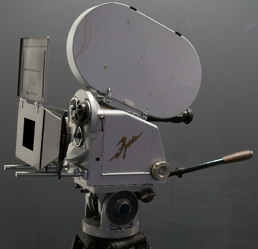 Movie reel and camera on a tripod 
