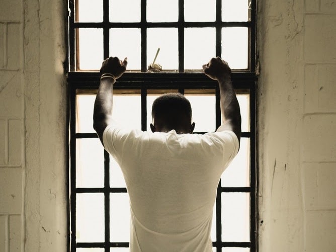 Man looking out of window with security bars