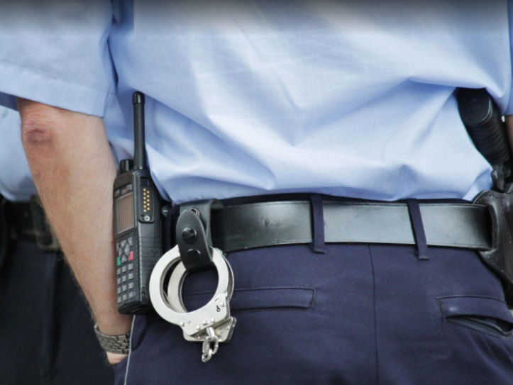 Police handcuffs, radio and gun in officer's belt holster