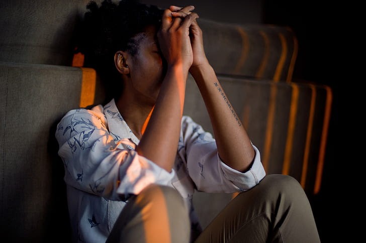 Woman with hands folded over face