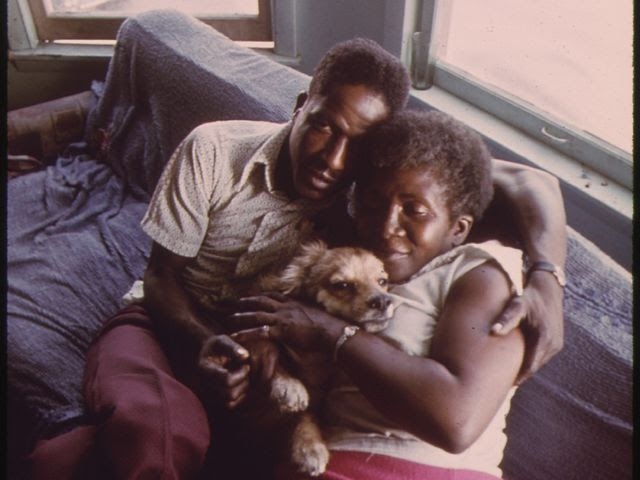 Man and woman hugging dog together