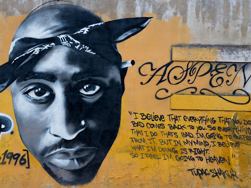 mural of tupac on yellow background a quote 