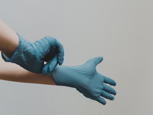 hands pulling blue latex gloves on