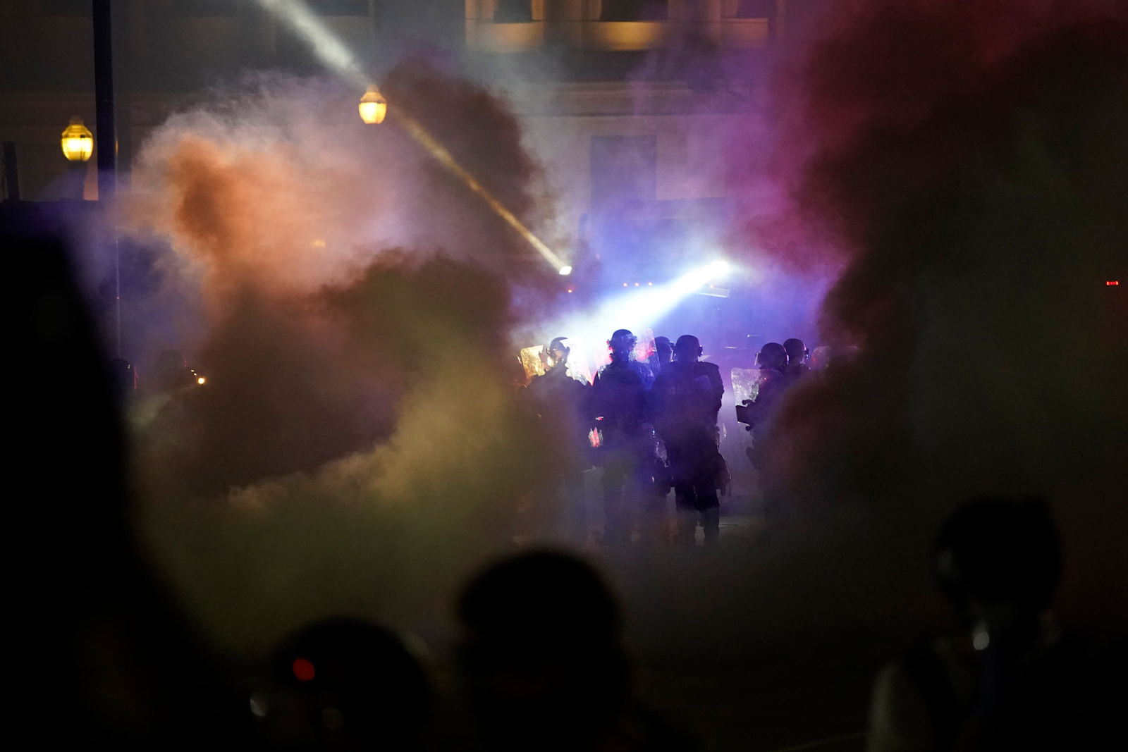 Uniformed officers walking through smoke