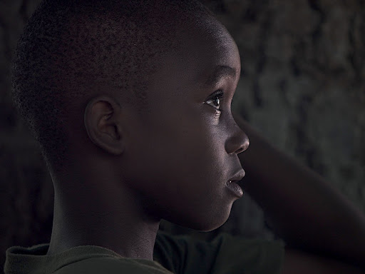small black child looking off into the distance 