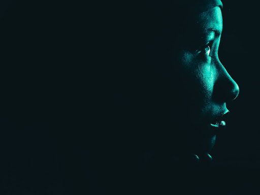 woman looking off into the distance in the dark 