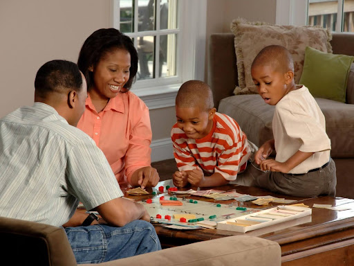 family sitting around a table boardgame