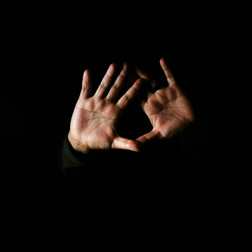 person holding both hands up in a green long sleeve shirt 