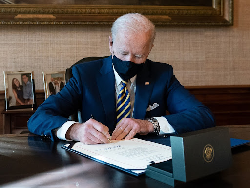 president biden sitting down signing orders