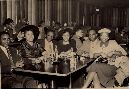 black men and women sitting around a table in a club