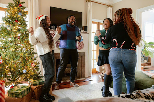 group of people standing around a christmas tree