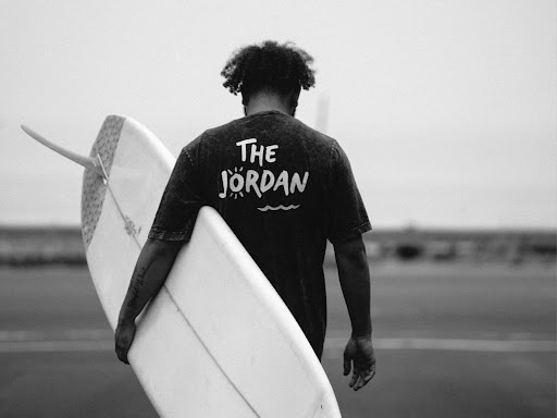 black surfer holding surf board