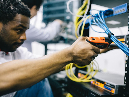 focused engineer using electric screwdriver