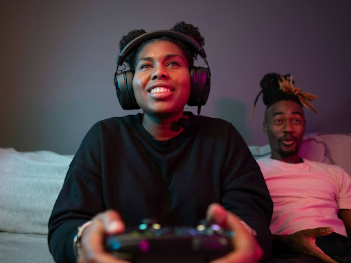two people sitting on a couch playing a video. game