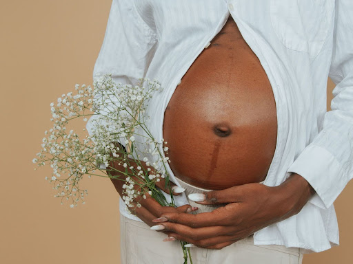 pregnant woman holding a bouquet of flowers 