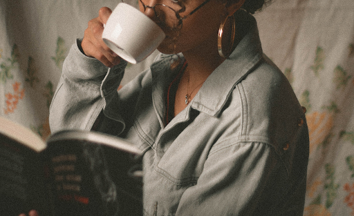 black woman drinking coffee in white ceramic mug