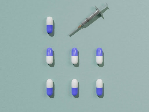 a group of blue and white pills next to a syquet