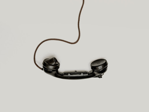 phone laying on the ground with a phone line attached