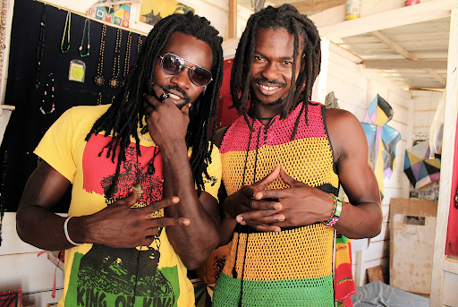 two black men standing together with dreads
