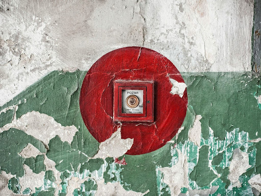 red button on a green and white wall