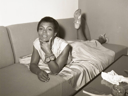 eartha kitt laying on her stomach on a couch