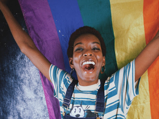 person holding a rainbow flag above their head