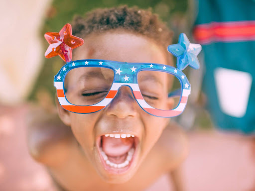 boy wearing american flag print eyeglasses sticking his mouth open