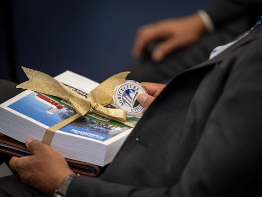 person sitting down with a lot of papers in their lap