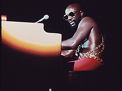 isaac hayes sitting at a piano and playing