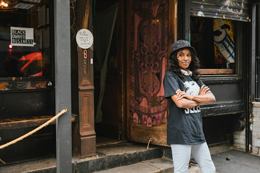 portrait of smiling female owner in front of cafe