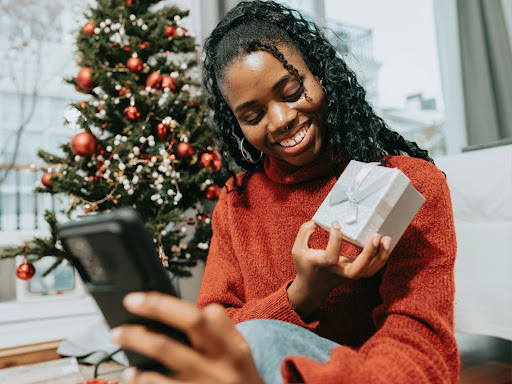 black woman in red sweater holding a present 