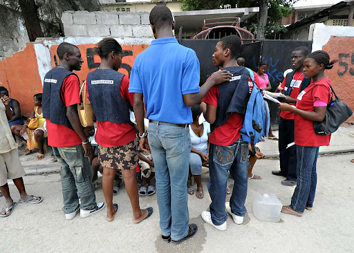 haitian students in red shirts are teach a class on sanitation