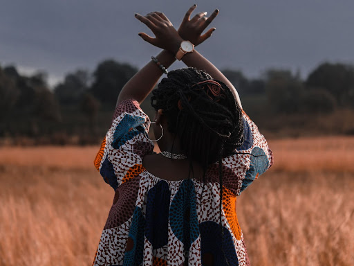 black person holding up arms crossed at wrist 