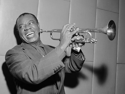 louis armstrong holding a trumpet and smiling